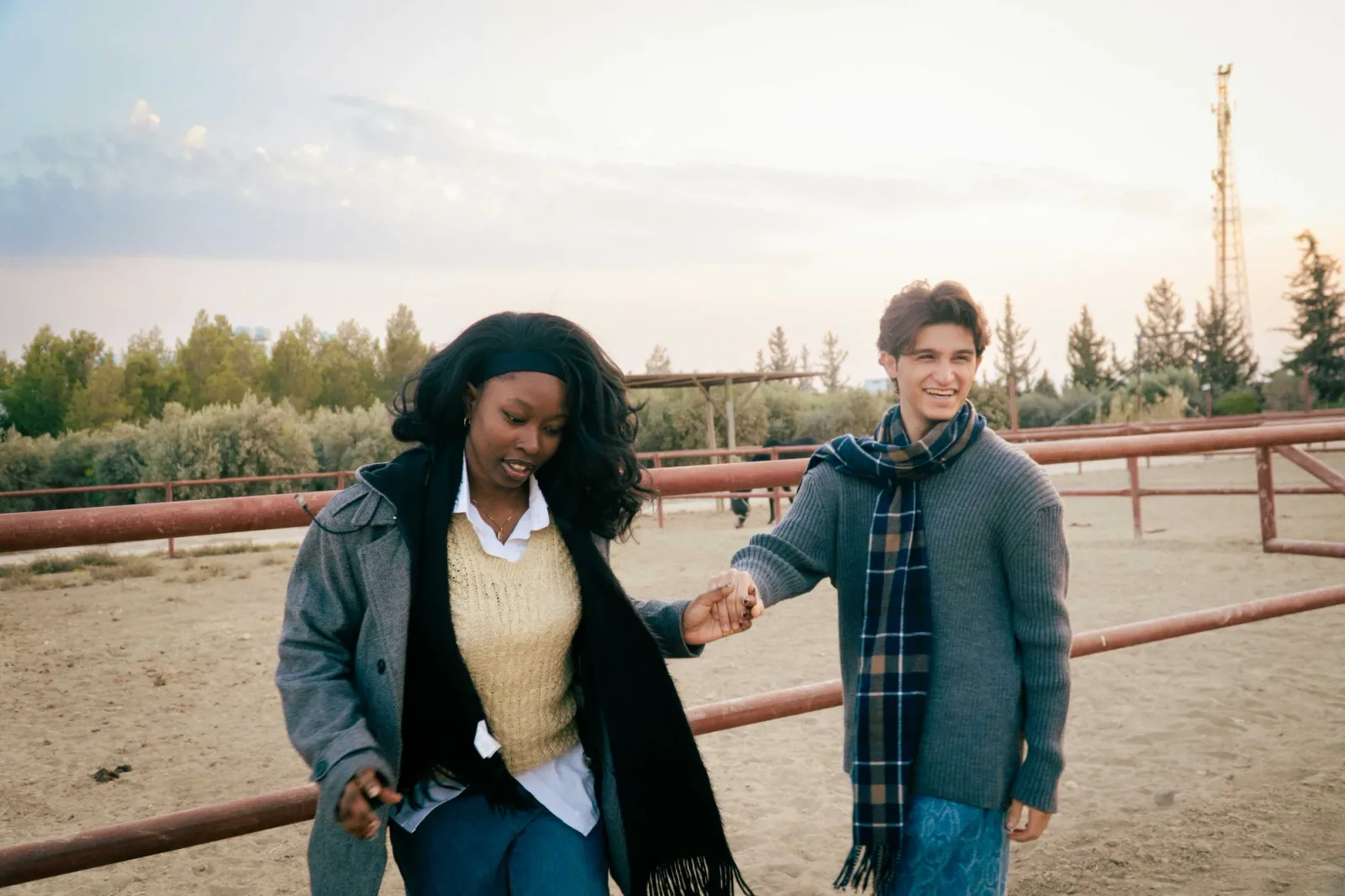 a couple walking together outdoors, holding hands, soft golden light.